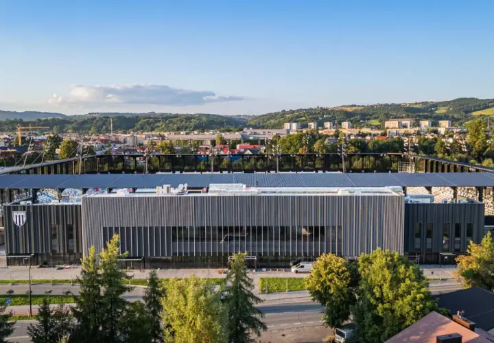 Nowoczesny stadion Sandecji w Nowym Sączu, otoczony zielenią i górami, gotowy na nowe emocje.