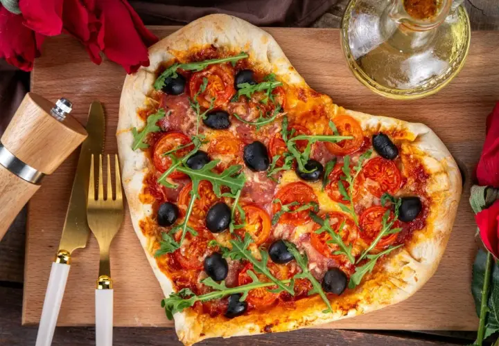 Pizza w kształcie serca z pomidorami, oliwkami i rukolą. Idealna na romantyczną kolację w domu, co ugotować?