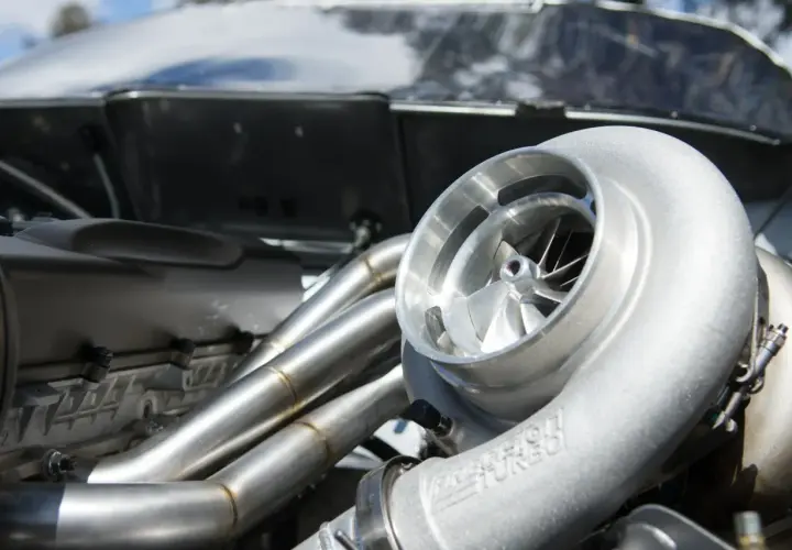 Błyszcząca turbina w aucie, gotowa do zwiększenia mocy. Widać jej wirnik i metalowe przewody.