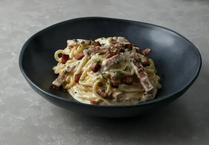 Pyszna carbonara w czarnej misce, idealna inspiracja, jak zrobić carbonare.