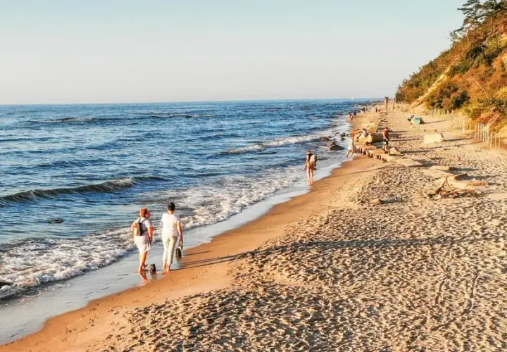 Spacer po plaży, idealne miejsce, gdzie jechać nad morze w listopadzie. Spokojne fale, piaszczysty brzeg i łagodne słońce.