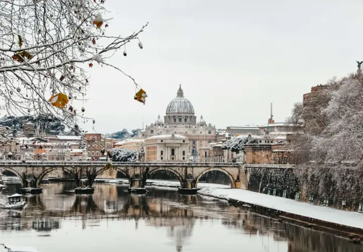 Roma innevata: la cupola di San Pietro e Ponte Sant'Angelo riflessi sul Tevere. Un raro freddo romano.