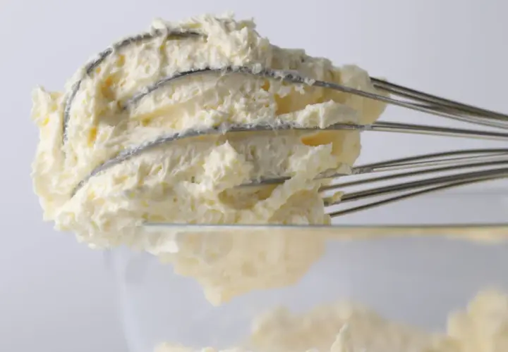 Puszysty krem mascarpone na drucianej trzepaczce, gotowy do deserów.