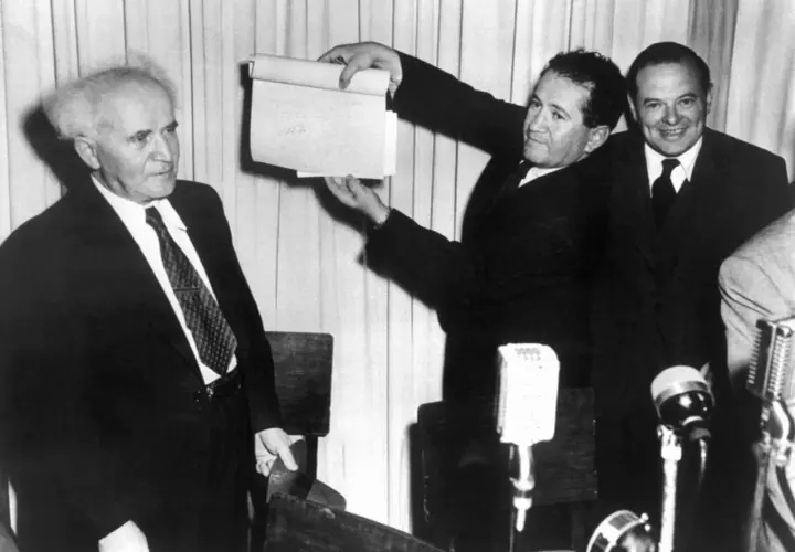 David Ben-Gurion hält ein Dokument hoch, das die Entstehung Israels symbolisiert.