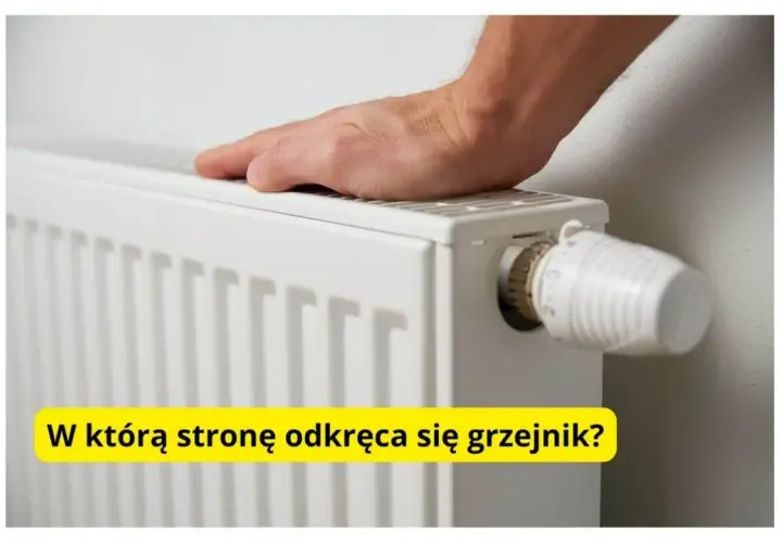 Dłoń na grzejniku, obok termostatu. Pytanie brzmi: w którą stronę się odkręca grzejnik, by było cieplej?
