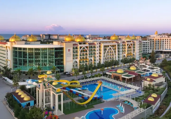 Luksusowy Alan Xafira Deluxe Resort & Spa z basenami i zjeżdżalniami, w blasku zachodzącego słońca.
