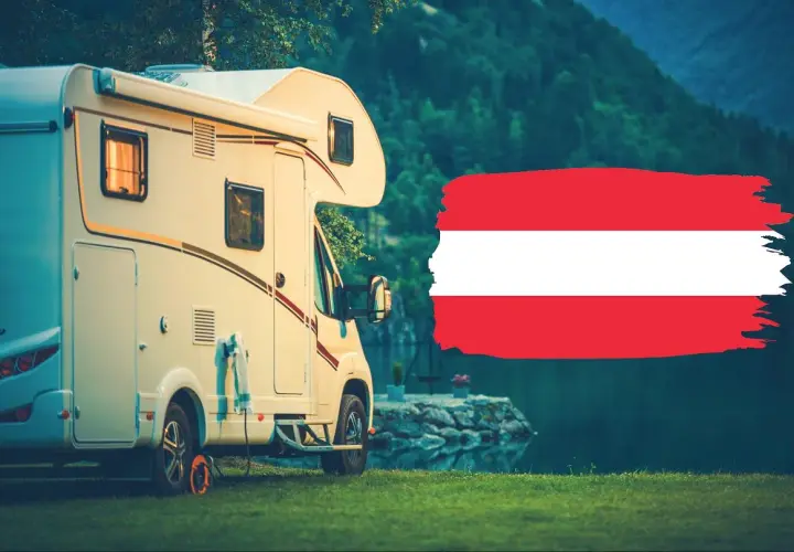 Kamper zaparkowany nad jeziorem w Karyntii, Austria. Obok flaga Austrii.