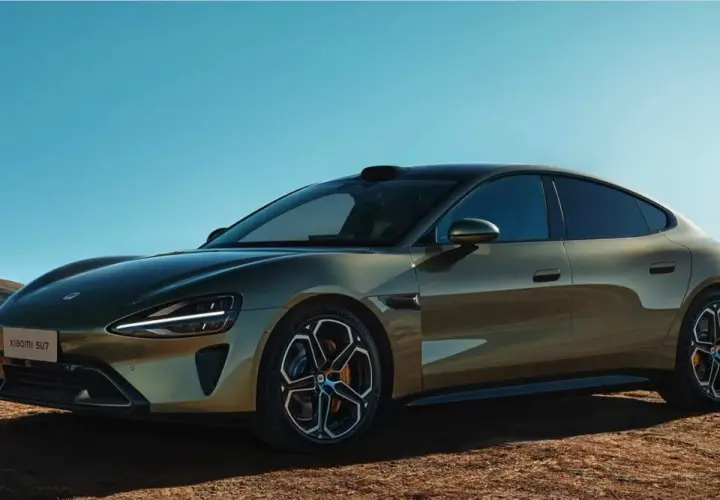 La nuova Xiaomi SU7, un'auto elettrica dal design audace, si presenta in un paesaggio desertico sotto un cielo azzurro.