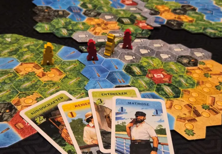 Spielbrett mit Figuren und Karten. Ein Seemann, Entdecker und andere Charaktere sind auf den Karten abgebildet. Ein spannendes Spiel für alle, die gute Brettspiele lieben.