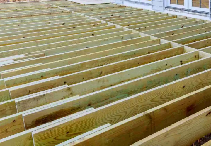 Structure en bois d'une terrasse en cours de construction, avec des solives de portée 63x175 espacées régulièrement.