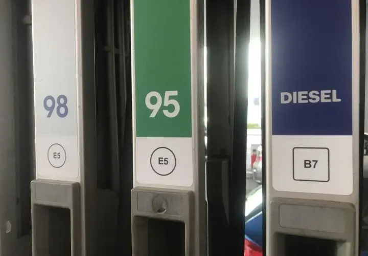 Kolumna z oznaczeniem diesla na stacji paliw, obok dystrybutorów 98 i 95.