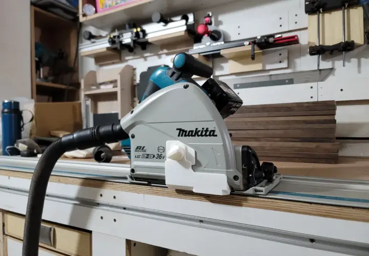 Sega circolare Makita su binario, pronta per tagliare profilo alluminio con precisione. Aspirazione collegata per un ambiente di lavoro pulito.