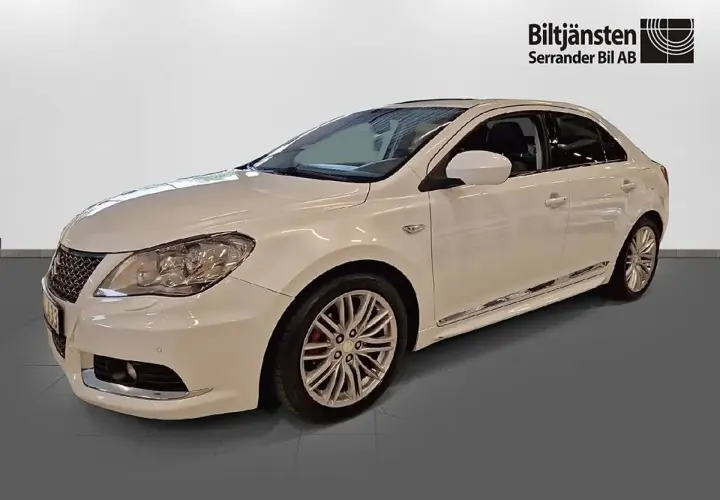 Vit Suzuki Kizashi, en elegant sedan med sportiga fälgar och kromdetaljer.