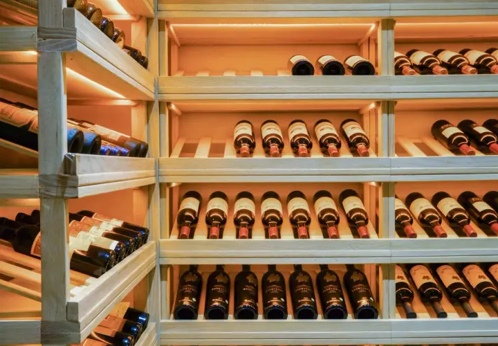 Étagères en bois remplies de bouteilles de vin, parfait pour faire sa cave à vin.