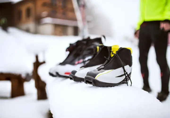 Buty narciarskie w śniegu. Zastanawiasz się, jak prać buty narciarskie? Oto one, gotowe do czyszczenia po dniu na stoku.