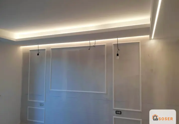 Soffitto in cartongesso con illuminazione a LED integrata e decorazioni a rilievo.