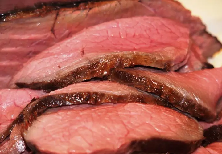 Tranches de rosbeef juteuses, parfaitement saisies, révélant une cuisson rosée idéale. Un délice pour les amateurs de viande.