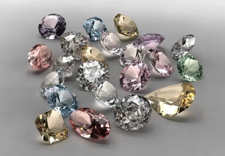 Bunte Edelsteine, was ist wertvoller als Diamant? Ein Haufen funkelnder, geschliffener Juwelen in Rosa, Blau, Grün und Gelb.