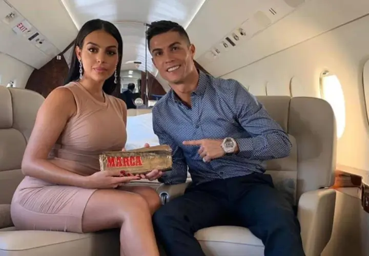 Georgina Rodriguez i Cristiano Ronaldo w prywatnym samolocie. Ona trzyma nagrodę "Marca", on wskazuje na nią.