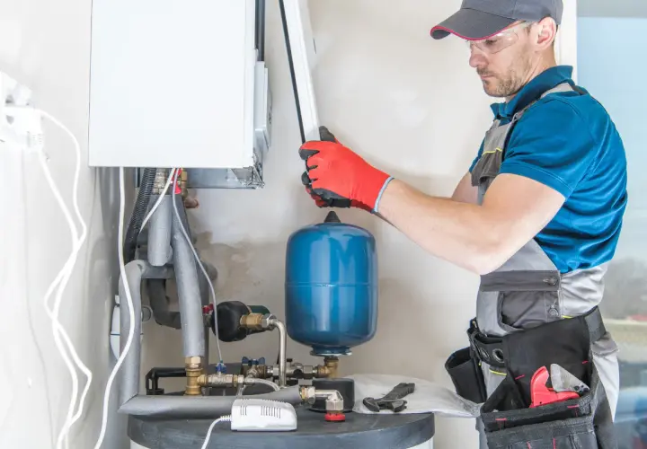 Instalator sprawdza podzespoły kotła gazowego, by dowiedzieć się, dlaczego piec gazowy buczy.