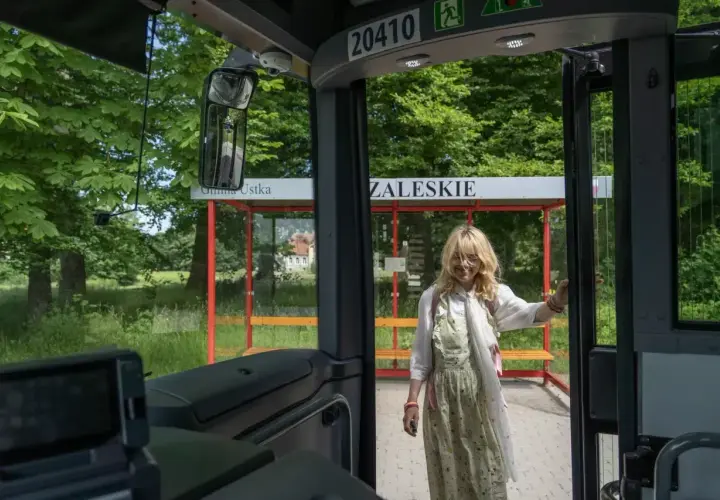 Dziewczyna wysiada z autobusu na przystanku Gmina Ustka. Słupsk i Ustka to miejsca, które warto odwiedzić.