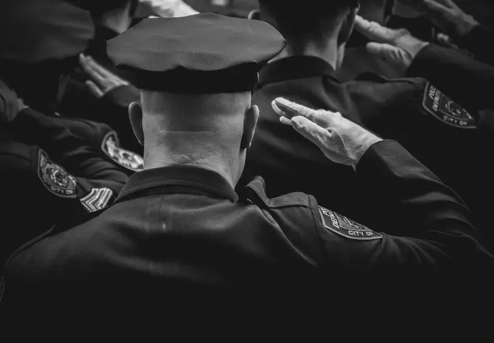 Policjanci w mundurach salutują. Dbanie o czystość munduru, jak prać mundur wojskowy, to ważny element służby.