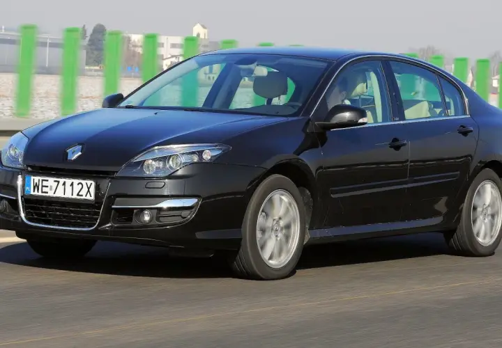 Czarny Renault Laguna 3 2.0 dCi w ruchu drogowym. Elegancki sedan z charakterystycznym przodem i felgami.