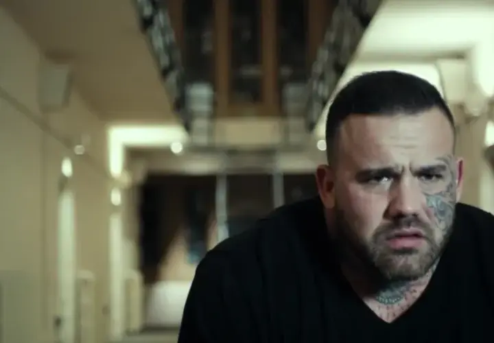Martyn Ford, acteur aux multiples tatouages, dans un couloir sombre. Une scène qui pourrait figurer dans ses films.