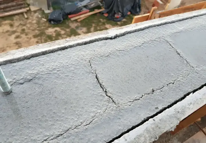 Betonowy wieniec budowlany z widocznymi pęknięciami, przygotowany do dalszych prac.