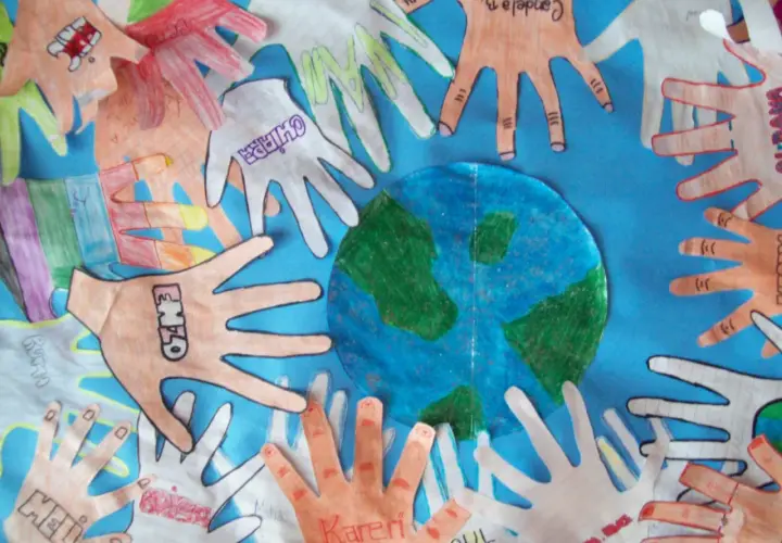 Manos de niños alrededor del planeta Tierra, celebrando actividades del Día de la Tierra.