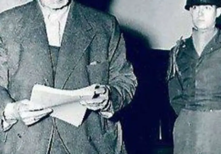 Ein Mann im Anzug hält Dokumente, daneben ein Soldat. Möglicherweise im Zusammenhang mit dem Flick-Konzern.