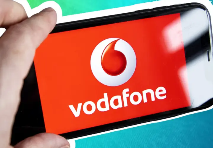 Vorsicht vor der neuen Betrugsmasche Vodafone! Ein Finger hält ein Smartphone mit dem Vodafone-Logo.