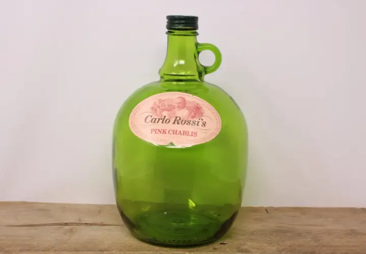 Zielona, szklana butelka Carlo Rossi Pink Chablis z uchwytem.