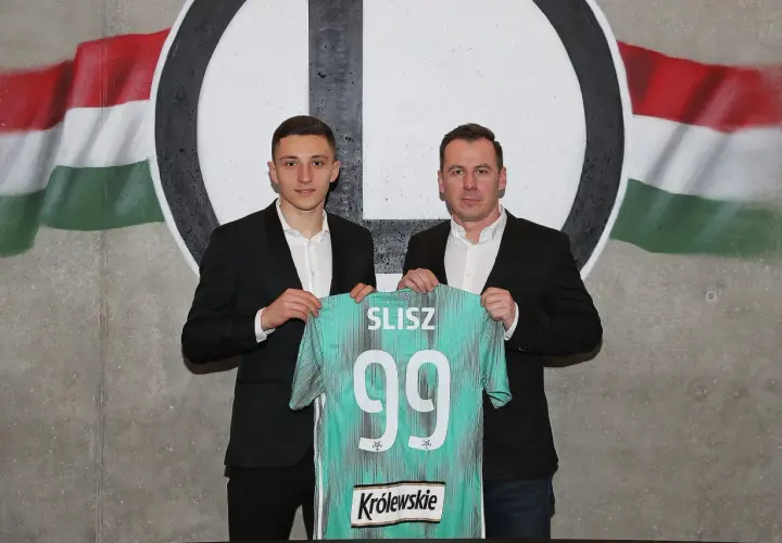 Dwóch mężczyzn prezentuje koszulkę z nazwiskiem SLISZ i numerem 99, symbolizującą rekord transferowy ekstraklasy.