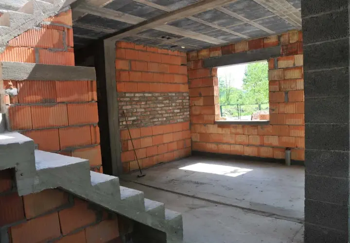 Wnętrze w budowie, ściany z pustaków ceramicznych, betonowe schody i strop. Trwa samowolne przekształcenie budynku gospodarczego na mieszkalny.