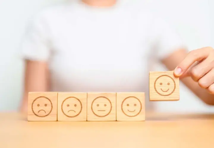 Una persona che se la prende subito, scegliendo un cubo con un sorriso tra faccine tristi e neutre.