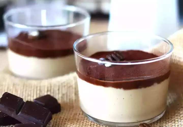 Deliziosa ganache al caffè espresso in bicchierini, guarnita con cacao e chicchi di caffè. Accanto, pezzi di cioccolato fondente.