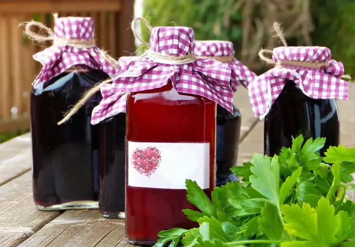 Domowe nalewki w butelkach, ozdobione kratkowanymi chusteczkami. Zastanawiasz się, ile procent ma spirytus użyty do ich produkcji?