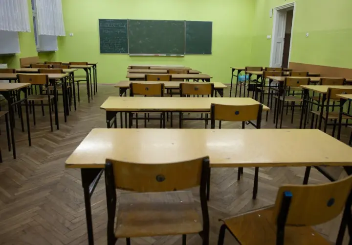 Puste ławki w sali lekcyjnej, czekające na powrót uczniów do szkoły po świętach wielkanocnych.