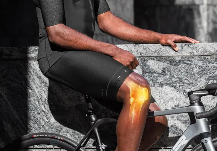 Rowerzysta z podświetlonym stawem kolanowym, sugerującym, czy jazda na rowerze obciąża kolana.
