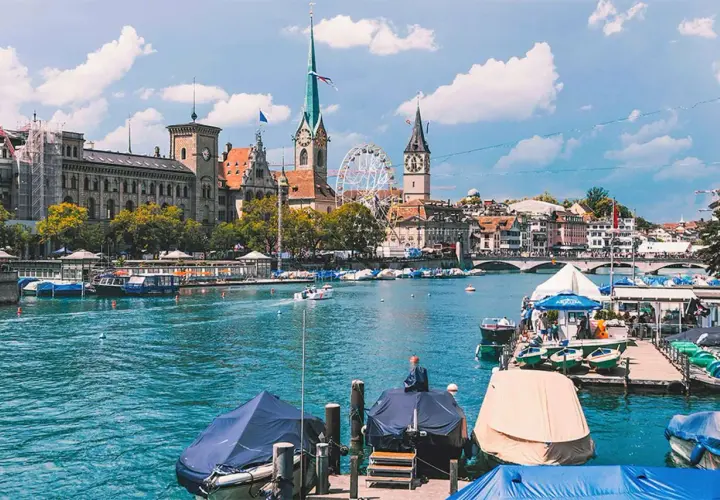 Widok na Zurych, największe miasto Szwajcarii, z rzeką Limmat, łodziami i zabytkową architekturą.