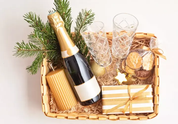 Festliche Fresskorb Ideen: Sektflasche, Gläser, Kerze, Kekse und Geschenk.