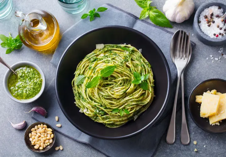 Pyszny pomysł na obiad bez mięsa: spaghetti z pesto, świeżą bazylią, orzeszkami pinii i parmezanem.