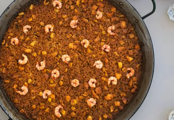 Arroz del senyoret en paellera, con gambas, trozos de calamar y patata. Un plato generoso y lleno de sabor.