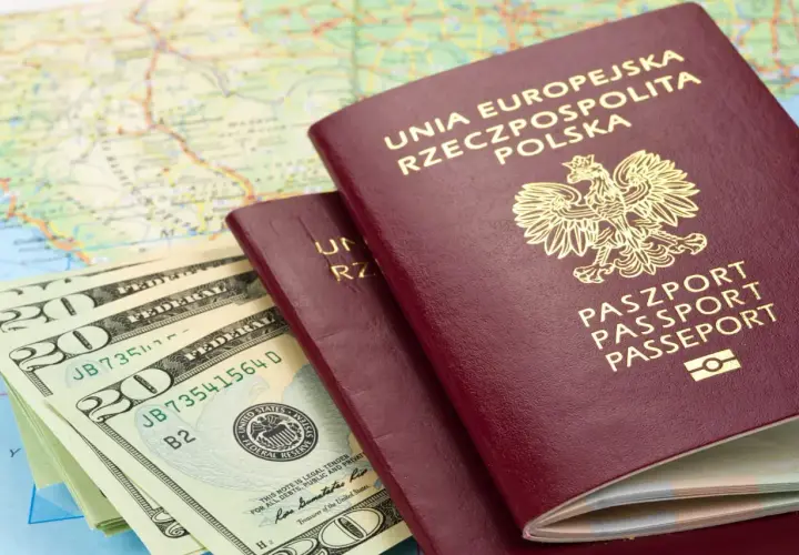 Dwa polskie paszporty i stos banknotów dolarowych na tle mapy. Czy do Rumunii potrzebny jest paszport? Sprawdź przed podróżą!