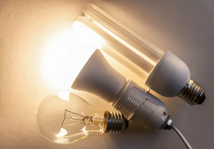 Trzy żarówki: tradycyjna, energooszczędna i adapter. Różne oznaczenia żarówek led i ich poprzedniczek.