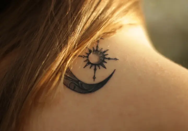 Tatouage lune et soleil sur la nuque, en phase de cicatrisation, une légère croûte est visible.