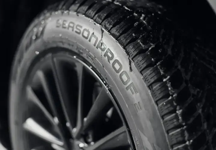 Opona Nokian Seasonproof z kroplami wody. Nokian to fińska firma, znana z produkcji opon zimowych i całorocznych.