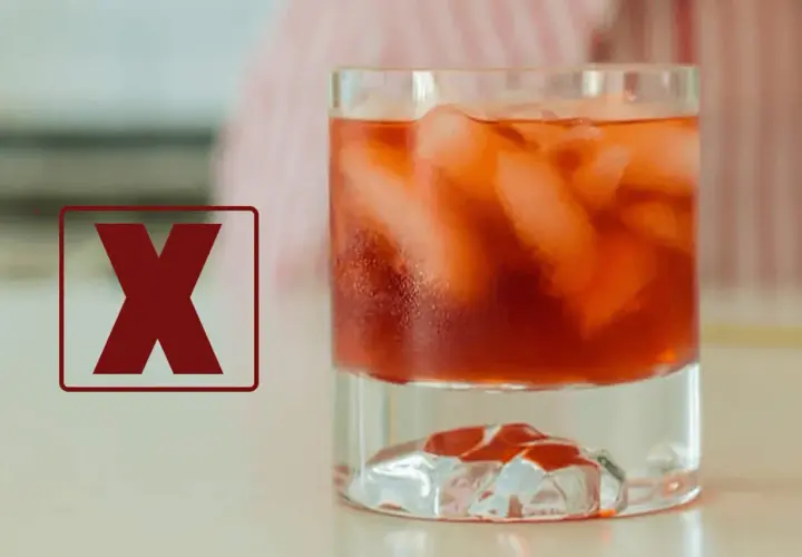 Czerwony znak "X" obok drinka z lodem. Dlaczego negroni musi być mieszane, a nie wstrząsane w shakerze, by zachować idealny smak.