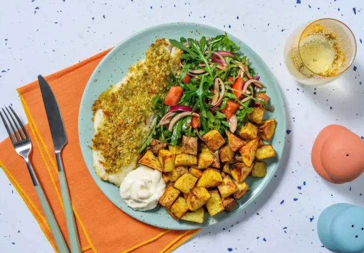 En tallrik med panerad torsk, krispiga potatisbitar, en fräsch sallad och en klick majonnäs. Ett perfekt torsk recept för en god middag.